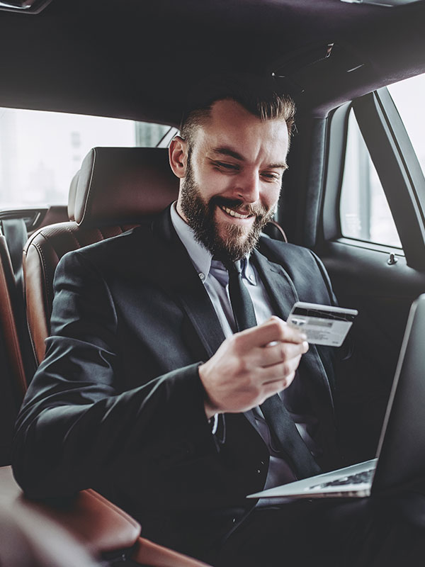A man in a suit looking at his credit card